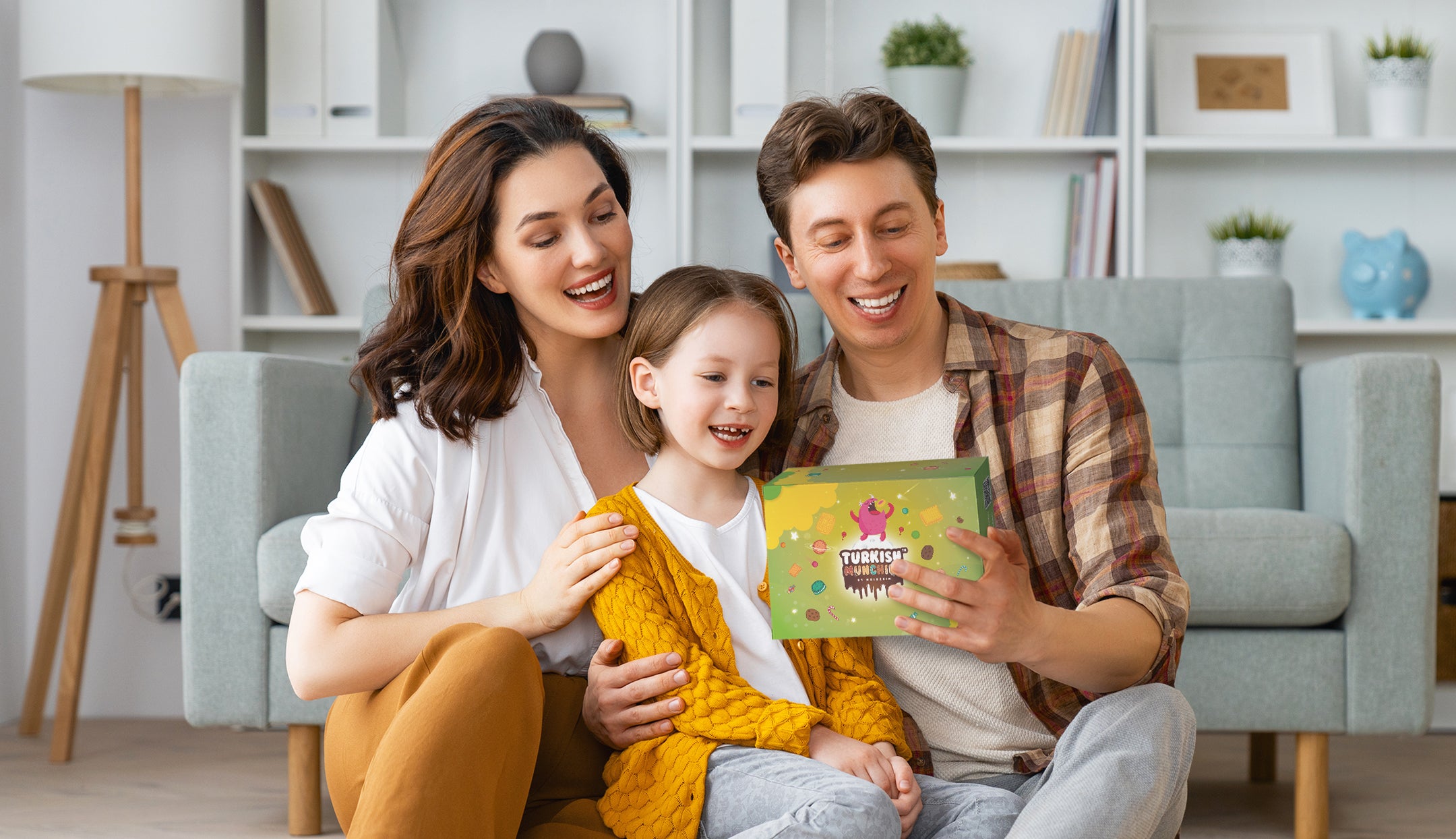 A family holding and smiling a box of Turkish Munchies Energetic Snack Box